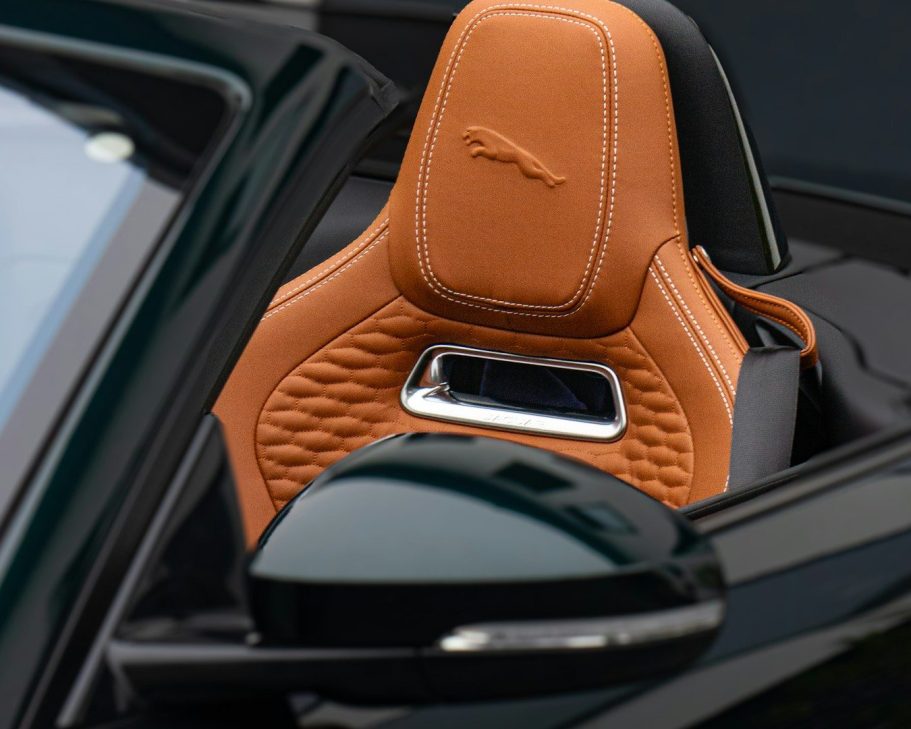 Close-up of a luxury car seat with an orange leather finish and a decorative stitching pattern.