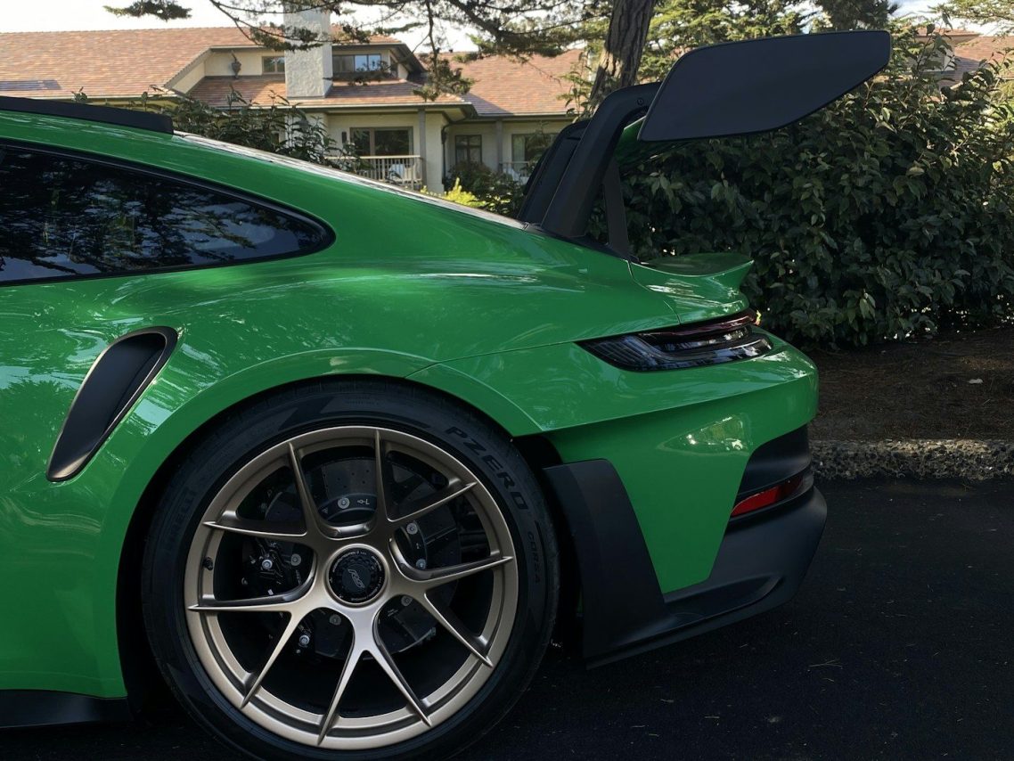 sandiegocardetailing Green sports car with a prominent rear spoiler and gold alloy wheels.